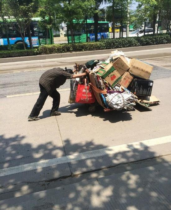 但是在武汉的街头正值正午时候,一位拾荒老人 顶着火辣的