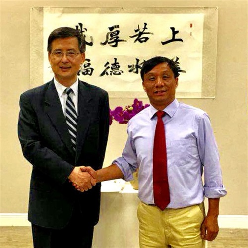解飞文化参赞在台上与王文大师亲切握手表示祝贺